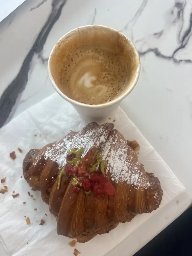 Coffee and a croissant on a marble table
